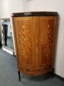 A reproduction bow fronted corner cabinet with inlaid panel doors,