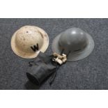 Two WWII metal helmets and a gas mask