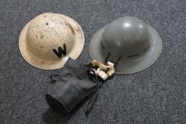 Two WWII metal helmets and a gas mask
