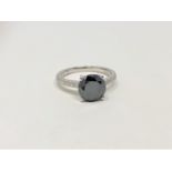 A 14ct white gold diamond ring, featuring centre round brilliant cut black diamond (1.