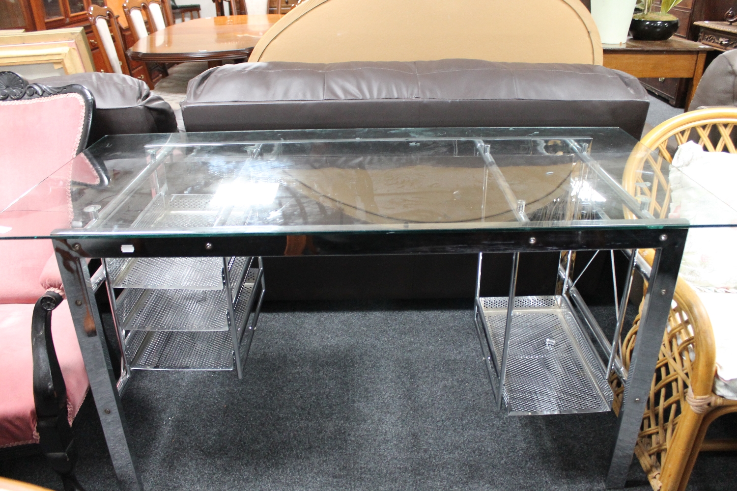 A steel framed and glass topped desk