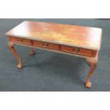 A Georgian style painted three drawer side table on claw and ball feet