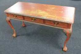 A Georgian style painted three drawer side table on claw and ball feet