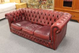 A red buttoned leather three seater Chesterfield settee