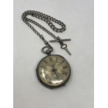 A large antique silver pocket watch with silver dial on heavy antique silver Albert chain