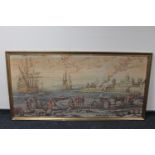 A gilt framed tapestry of boats landing in a harbour