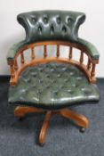 A green leather reproduction swivel armchair
