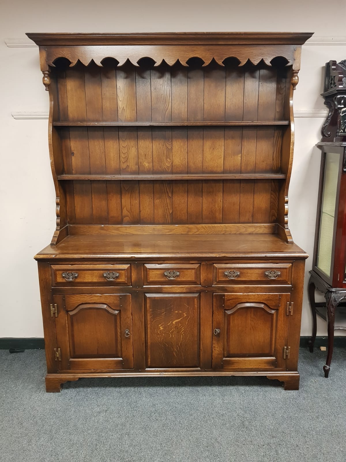 A Georgian style oak dresser fitted with drawers and cupboards,