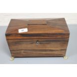 A Regency rosewood tea caddy on brass paw feet