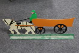 A painted metal stand depicting a farmer with cart horse