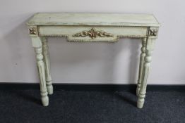 A traditional style cream finished side table