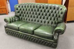 A green buttoned leather Chesterfield three seater settee,