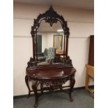 A heavily carved console table on cabriole legs with mirror back,