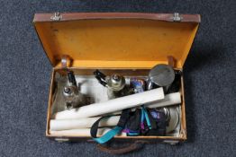 A vintage brown leather case containing silver plated pieces,
