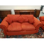 A contemporary four seater and two seater settees upholstered in burnt rust coloured fabric,