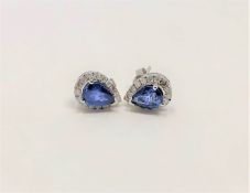 A pair of 14ct white gold sapphire and diamond earrings, featuring two pear cut blue sapphires (1.