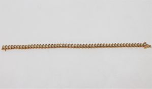 A 10ct yellow gold diamond set line bracelet, set with fifty brilliant-cut diamonds,