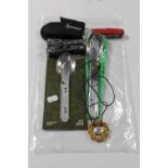 A bag containing Gerber multi tool pocket knife, military cutlery,