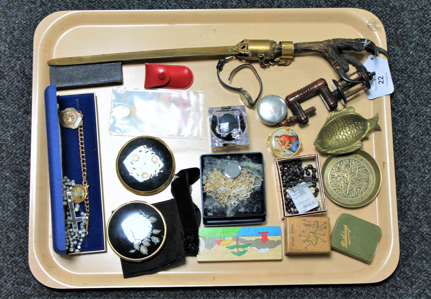 A tray of religious pendants, rosary beads, brass trinket trays, compacts,