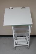 A metal medical trolley with adjustable top,