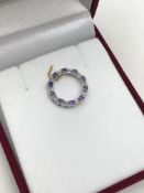 A 10ct white gold diamond and amethyst circular pendant