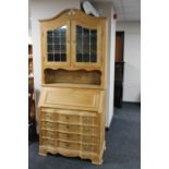 A blond oak bureau bookcase with leaded glass doors