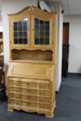 A blond oak bureau bookcase with leaded glass doors