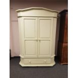 A painted double door wardrobe fitted drawer beneath,