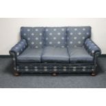 A traditional style three seater settee in blue fabric
