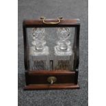 A mahogany two decanter Tantalus with two cut glass whisky decanters