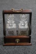 A mahogany two decanter Tantalus with two cut glass whisky decanters