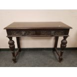 A carved oak two drawer side table,