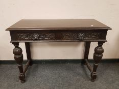 A carved oak two drawer side table,