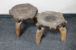 A pair of three legged tribal stools