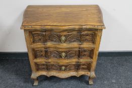 A shaped beech wood three drawer chest