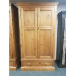 A contemporary pine double door wardrobe fitted a drawer,