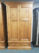 A contemporary pine double door wardrobe fitted a drawer,