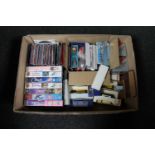 A box containing VHS cassette tapes, crested teaspoons,