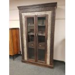 An Eastern carved hardwood glazed double door cabinet fitted with two drawers ,
