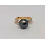 A 14ct gold diamond and Tahitian pearl ring, the total diamond weight 0.61 carat, size L.