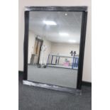 A black framed overmantel mirror