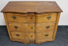 An antique continental serpentine front three drawer chest with brass drop handles