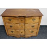 An antique continental serpentine front three drawer chest with brass drop handles