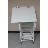 A metal medical trolley with adjustable top,