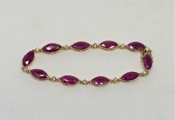 A 14ct yellow gold ruby and diamond bracelet, set with ten marquise-cut rubies (14.