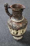 A continental embossed pottery ewer,