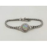 A 14ct white gold opal and diamond bracelet, the Australian cabochon opal weighing 3.