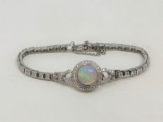 A 14ct white gold opal and diamond bracelet, the Australian cabochon opal weighing 3.