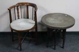An antique elbow chair together with a folding eastern copper topped table