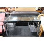 A steel framed and glass topped desk